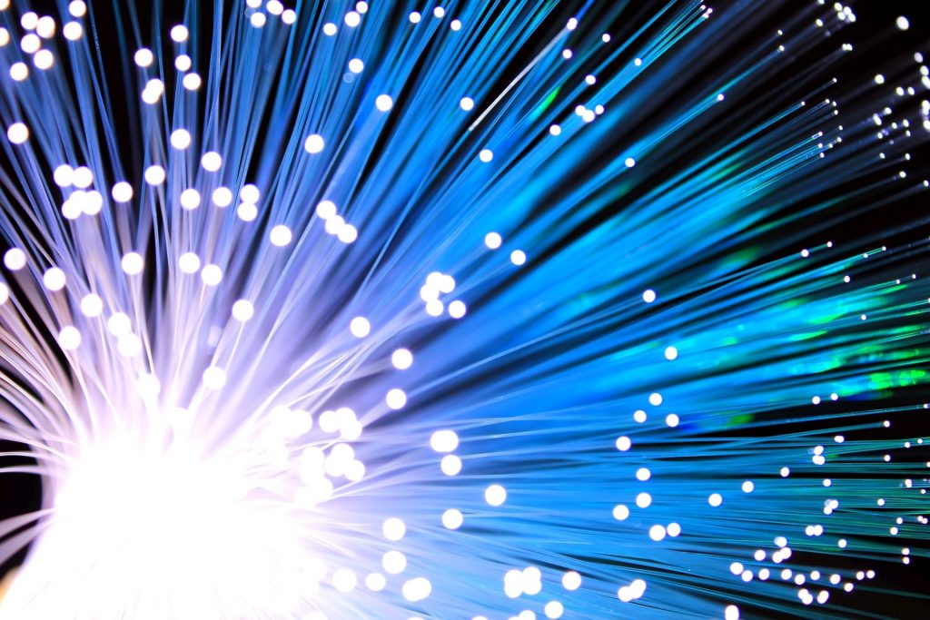 An inverted image of the end of an optical fibre, with a white background and dark wires