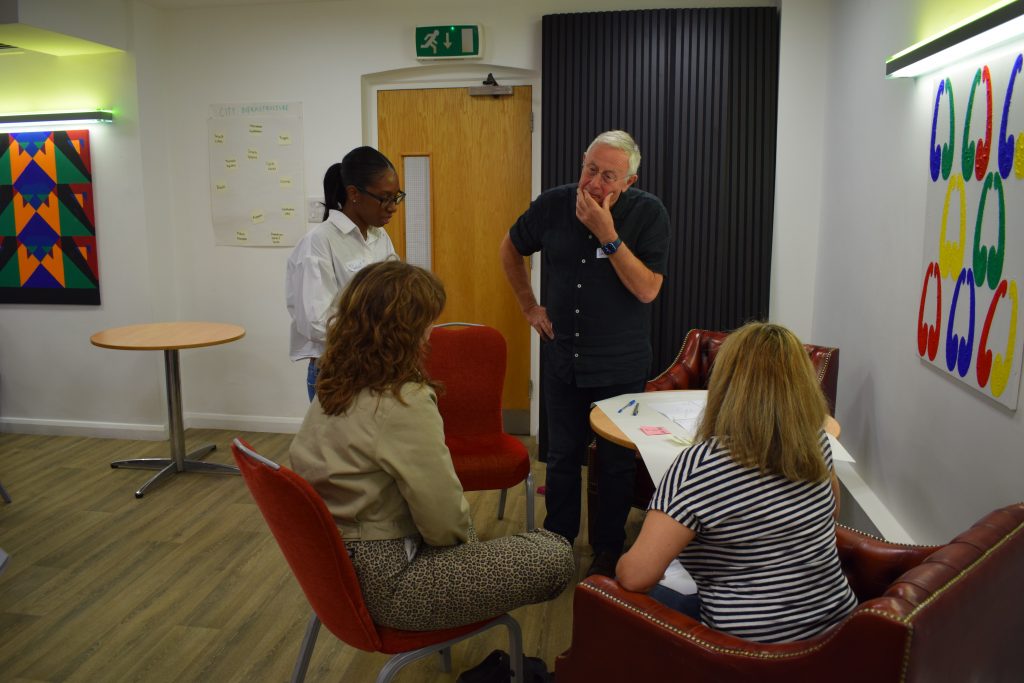 A group of four people positioned around a table having a discussion