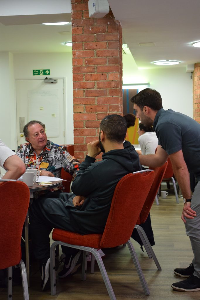 Three people having a discussion at beside a table